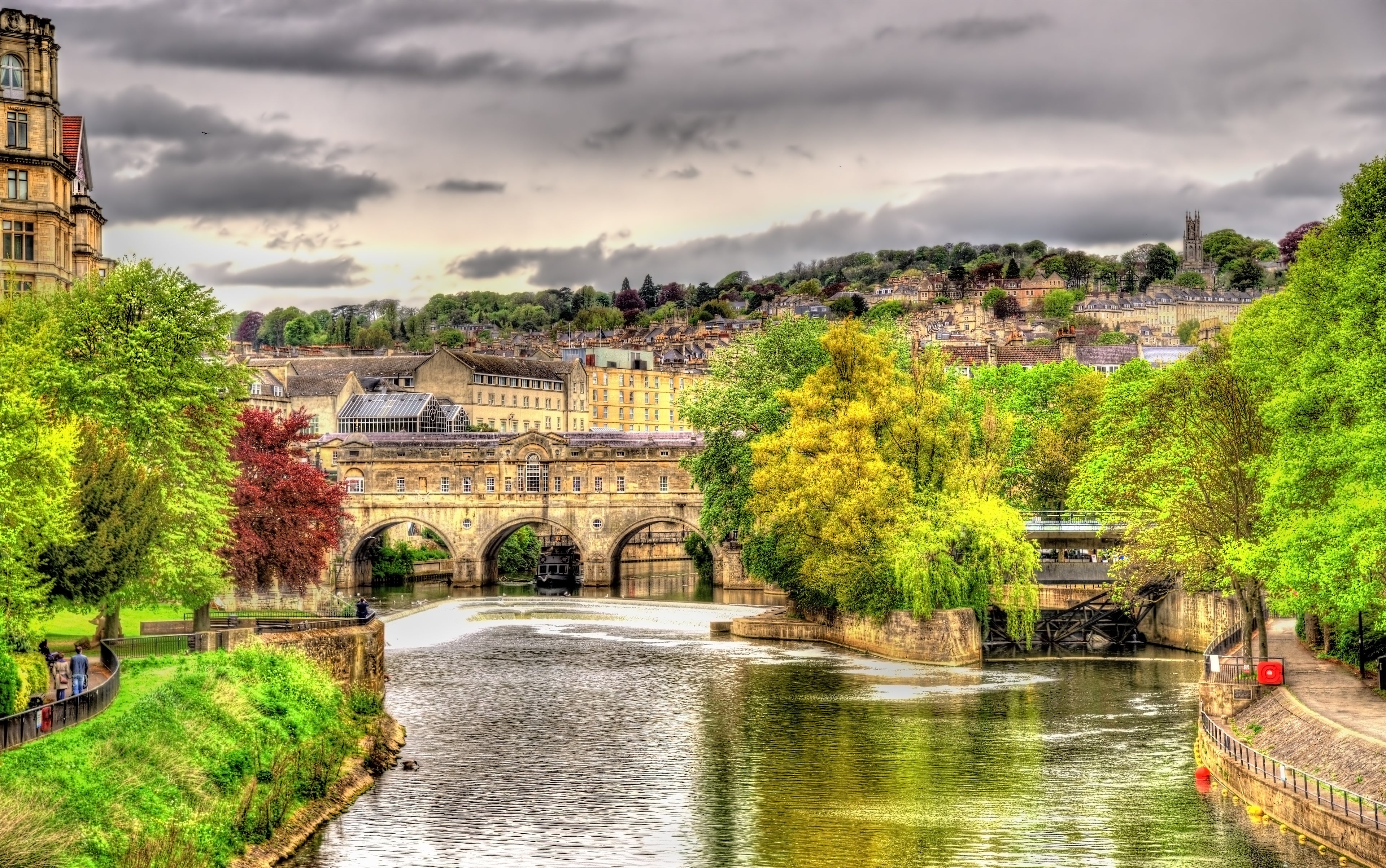 River with a bridge and buildings under a cloudy sky