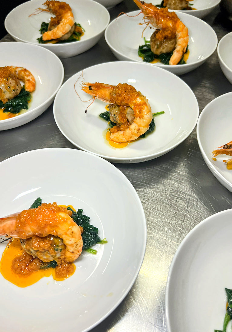 Multiple plates of shrimp dish on a metal surface
